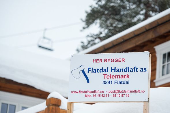 Flatdal Handlaft AS skilt foran en hytte